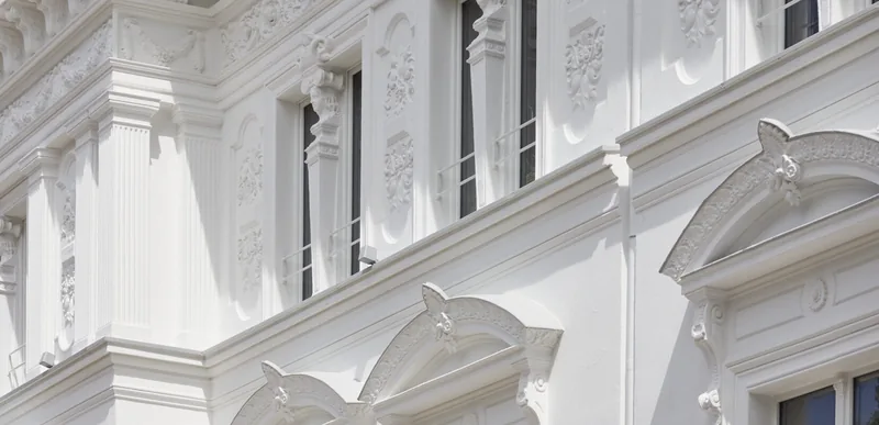 Stuck-Detail an der Fassade des Rubedo Spa in der Marienstraße 58, Minden — Blumen-Reliefs und kannelierte Pilaster